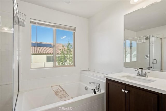 bathroom with vanity and shower with separate bathtub