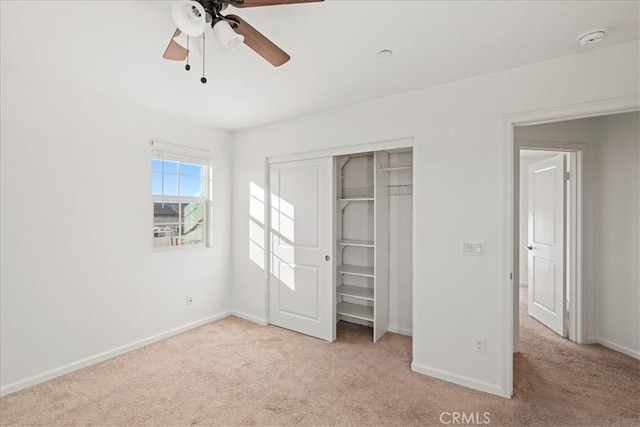 unfurnished bedroom with ceiling fan, a closet, and light colored carpet