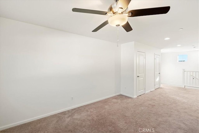 spare room with ceiling fan and light colored carpet