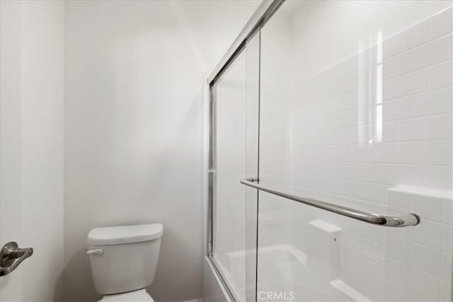 bathroom with toilet and enclosed tub / shower combo