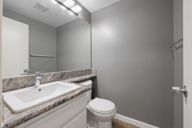 bathroom featuring toilet, vanity, and tile patterned floors