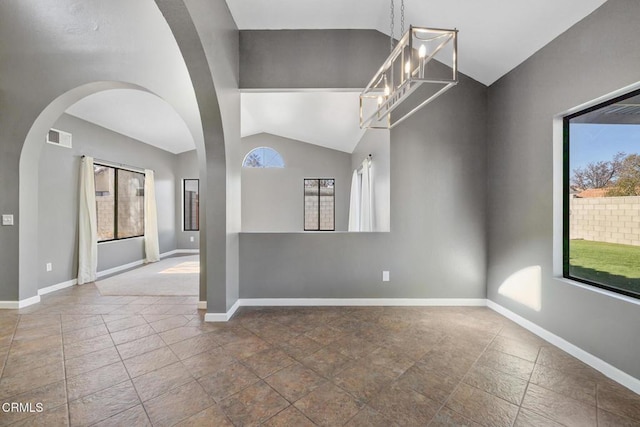 empty room featuring vaulted ceiling and a notable chandelier