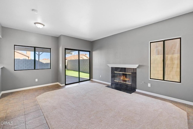 unfurnished living room featuring a premium fireplace and carpet