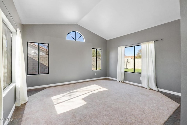 spare room with lofted ceiling and dark colored carpet