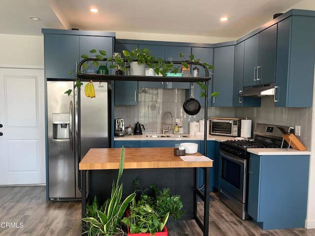 kitchen featuring appliances with stainless steel finishes, blue cabinets, and dark hardwood / wood-style flooring