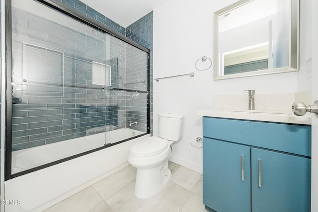 full bathroom featuring toilet, bath / shower combo with glass door, tile patterned flooring, and vanity