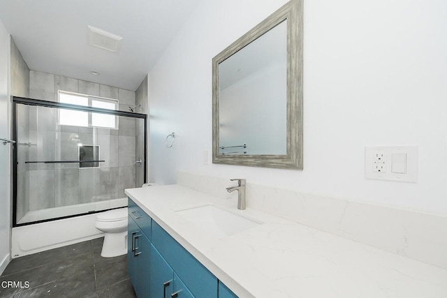 full bathroom with toilet, tile patterned floors, vanity, and shower / bath combination with glass door