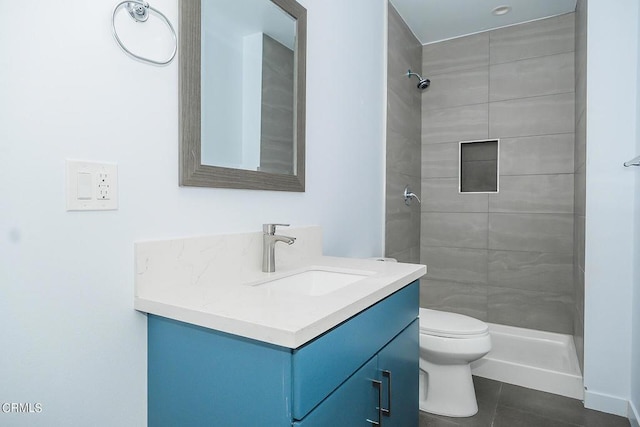 bathroom with toilet, tile patterned floors, tiled shower, and vanity