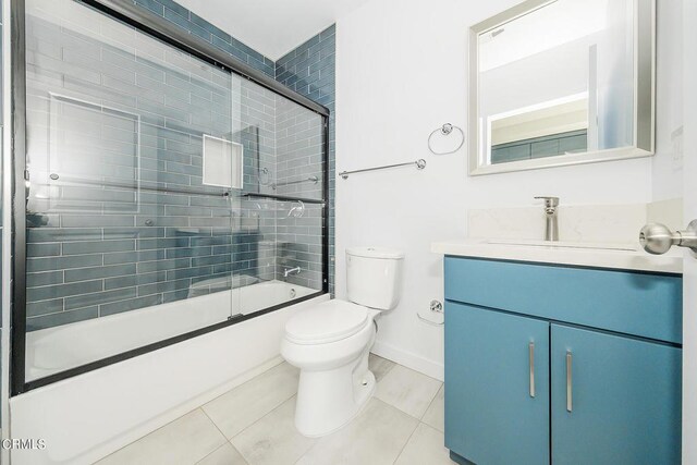 full bathroom featuring toilet, tile patterned flooring, enclosed tub / shower combo, and vanity