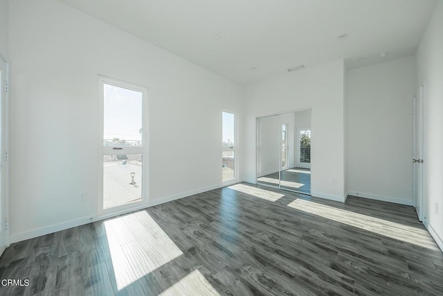 unfurnished room with dark hardwood / wood-style flooring