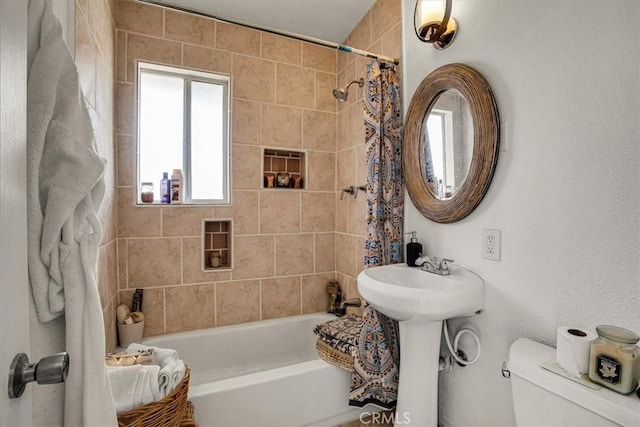 bathroom featuring toilet and shower / tub combo with curtain