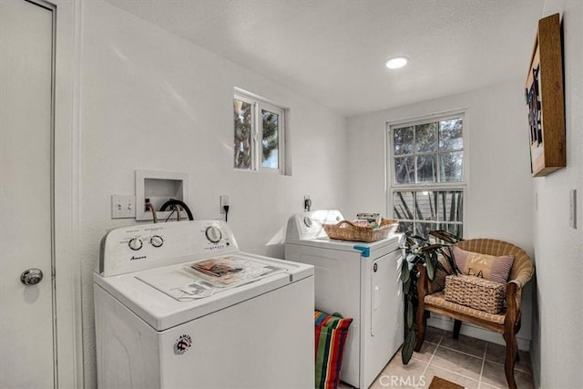 laundry room with washer and clothes dryer, a wealth of natural light, and light tile patterned floors