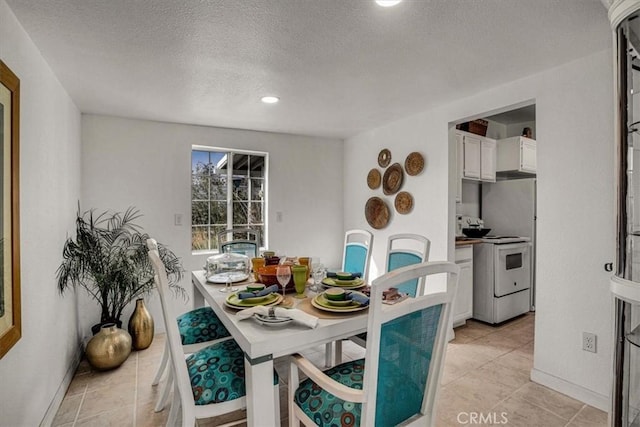 tiled dining area featuring a textured ceiling