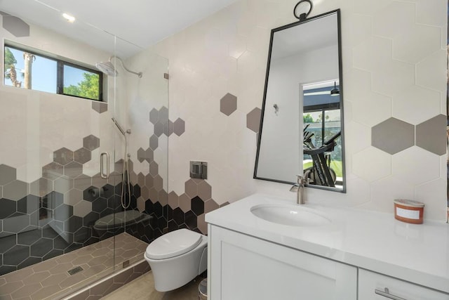 bathroom featuring toilet, vanity, tile walls, and a shower with shower door