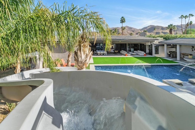 view of swimming pool with pool water feature, a patio area, and a mountain view