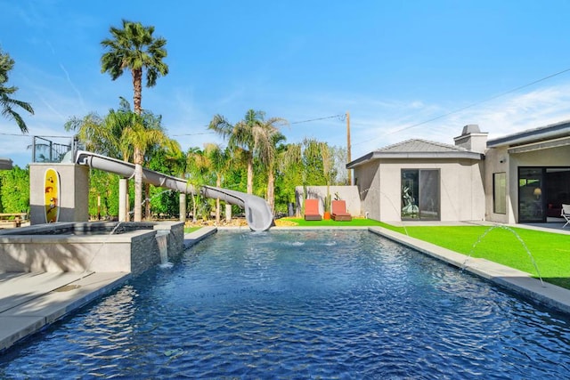 view of pool featuring a jacuzzi, a lawn, a water slide, and pool water feature