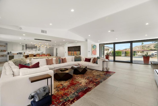 living room with lofted ceiling, expansive windows, and a notable chandelier