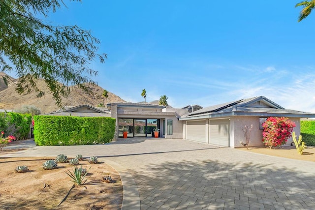 view of front of house with a mountain view and solar panels