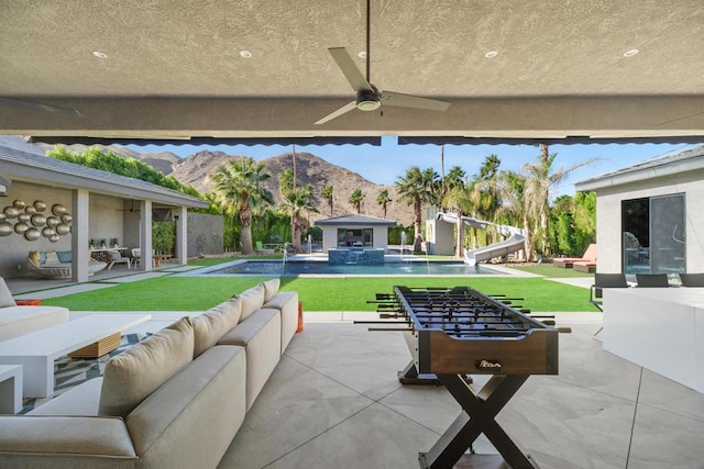 view of patio featuring a mountain view, ceiling fan, and an outdoor hangout area