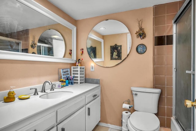 full bathroom featuring toilet, vanity, and bath / shower combo with glass door