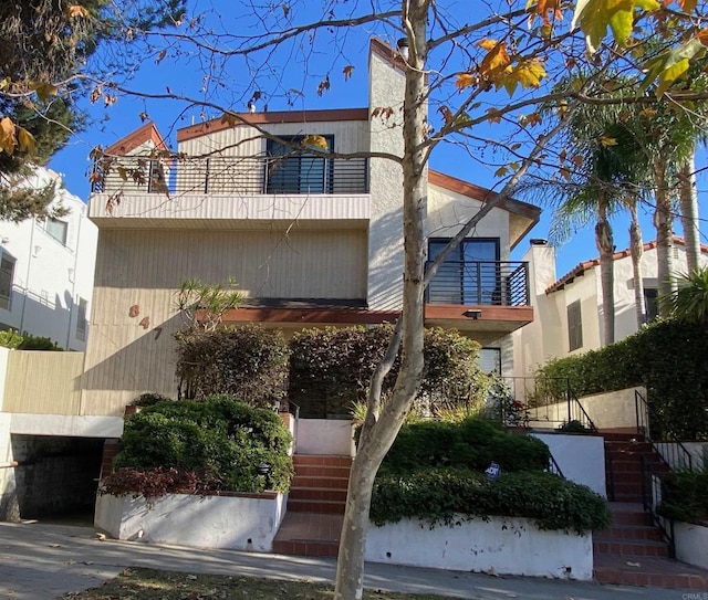 view of front of house with a balcony and stairs