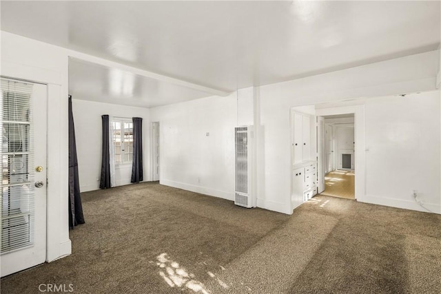 empty room with beamed ceiling and carpet flooring