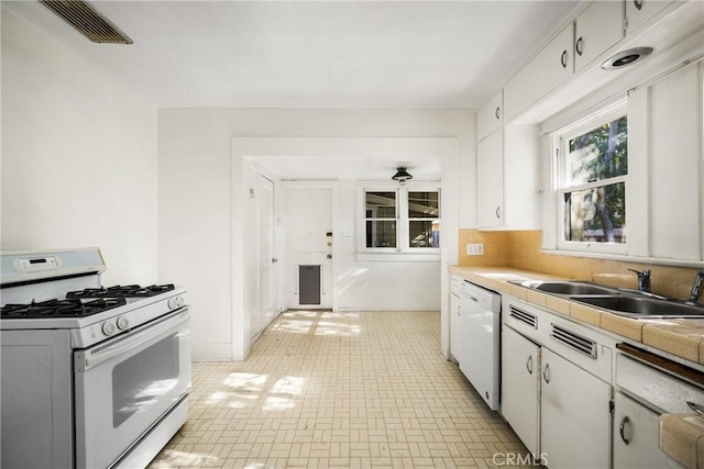 kitchen featuring white cabinetry, sink, white appliances, and tasteful backsplash