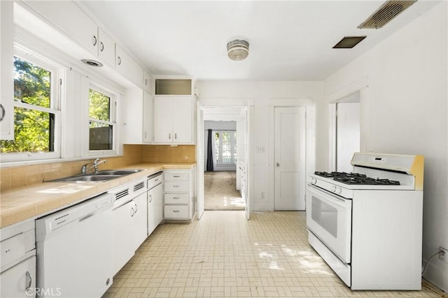 kitchen featuring white cabinetry, backsplash, white appliances, and sink