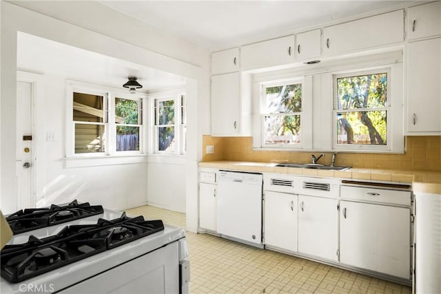 kitchen with decorative backsplash, sink, white appliances, and white cabinets