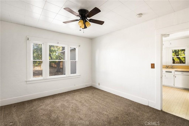 carpeted spare room featuring ceiling fan and plenty of natural light