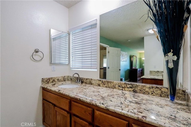 bathroom featuring a textured ceiling and vanity