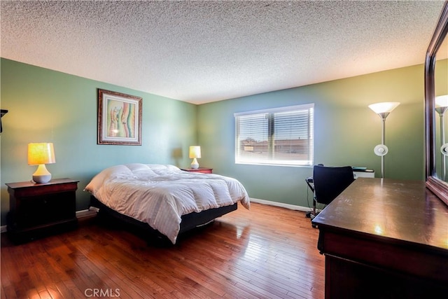 bedroom with wood-type flooring and a textured ceiling