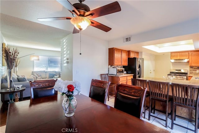 tiled dining area featuring ceiling fan