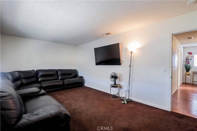 living room with a textured ceiling and dark colored carpet