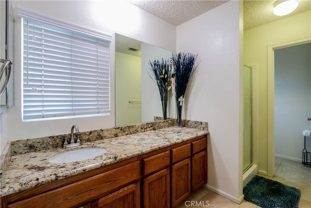 bathroom featuring a textured ceiling, tile patterned floors, walk in shower, and vanity