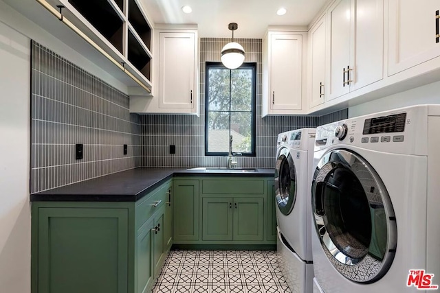 clothes washing area with cabinets, light tile patterned floors, independent washer and dryer, and sink