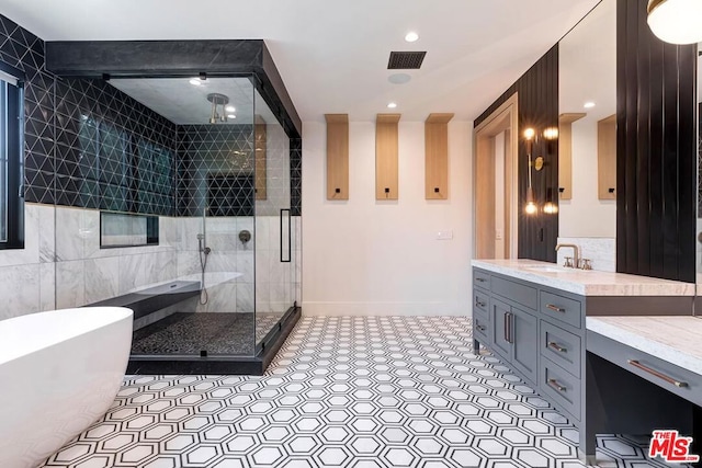 bathroom with tile patterned flooring, tile walls, vanity, and plus walk in shower