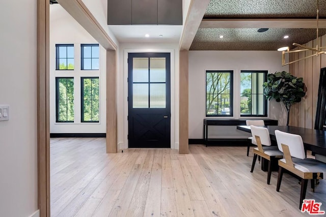 entryway featuring light hardwood / wood-style flooring and beam ceiling