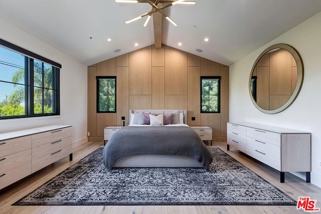 bedroom featuring ceiling fan with notable chandelier, lofted ceiling with beams, and light wood-type flooring