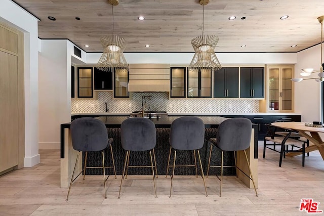 kitchen featuring decorative light fixtures, decorative backsplash, wood ceiling, and light hardwood / wood-style flooring