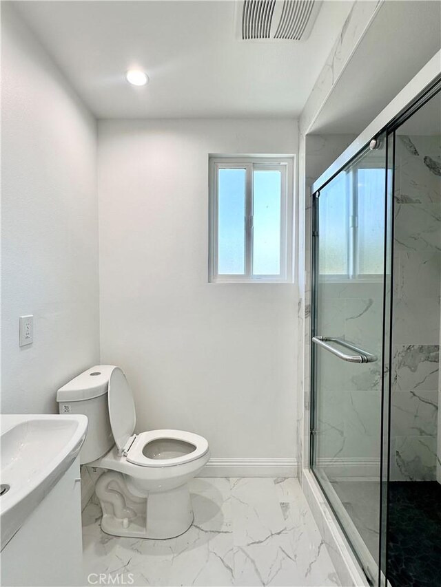 bathroom with an enclosed shower, vanity, and toilet