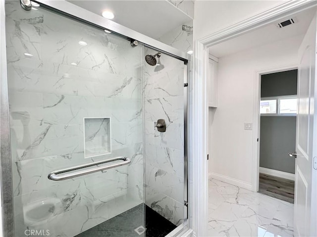 bathroom featuring a shower with door