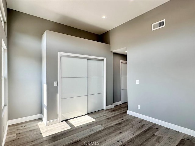 unfurnished bedroom with light wood-type flooring and a closet