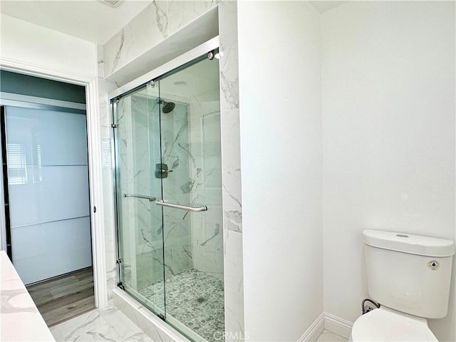 bathroom featuring toilet and an enclosed shower