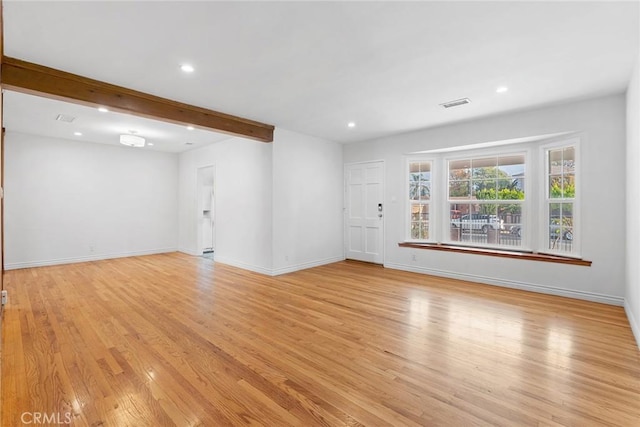 unfurnished living room featuring light hardwood / wood-style floors and beamed ceiling