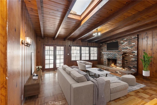 living room featuring light parquet flooring, a brick fireplace, wood walls, wood ceiling, and french doors