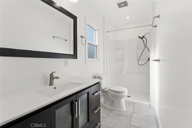 bathroom featuring toilet, vanity, tile patterned flooring, and walk in shower