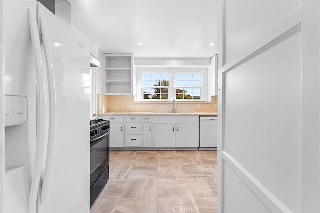 kitchen featuring decorative backsplash, sink, white appliances, and white cabinets