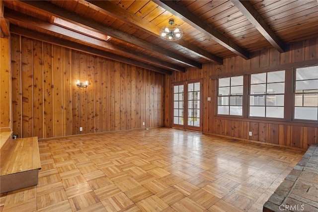 unfurnished room with wooden ceiling, beam ceiling, light parquet flooring, and wooden walls