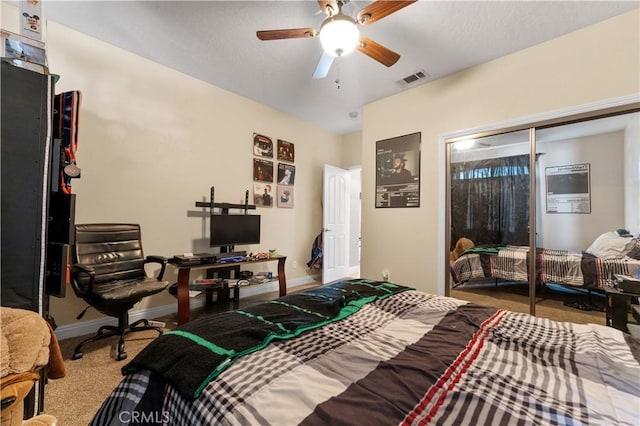 carpeted bedroom featuring ceiling fan and a closet